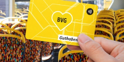Eine Person hält die BVG Guthabenkarte in die Kamera und steht dabei in einem Bus.