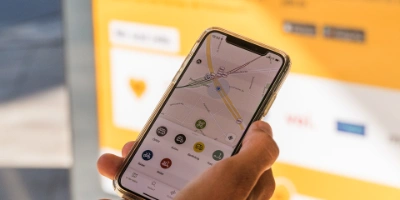 A hand holds a smartphone on which the Jelbi app can be seen.