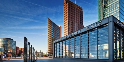 Blick auf den Mauerwalk am Potsdamer Platz, mit verglasten Gebäuden im Hintergrund.