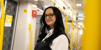 Eine Frau in BVG-Kleidung steht in einer U-Bahn