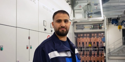 Elektroniker Bassel steht vor den Anlagen in einem Gleichrichterwerk