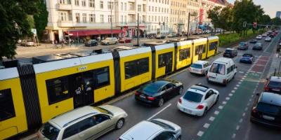 Eine Tram der BVG am Frankfurter Tor. Daneben stauen sich die Autos.