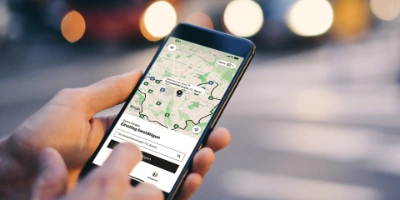 Eine Hand hält ein Smartphone, auf dem Bildschirm ist die Oberfläche der BVG Muva-App zu sehen.