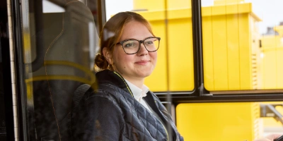 Frau sitzt am am Steuer beim Bus