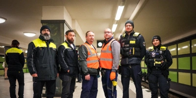 Sicherheits- und Reinigungskräfte stehen auf U-Bahnhof