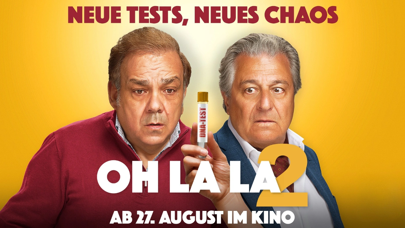 Zwei Männer blicken mit überraschten Gesichtern auf einen DNA-Test. Das Bild bewirbt die Komödie „Oh La La 2“, die ab dem 27. August im Kino zu sehen ist.