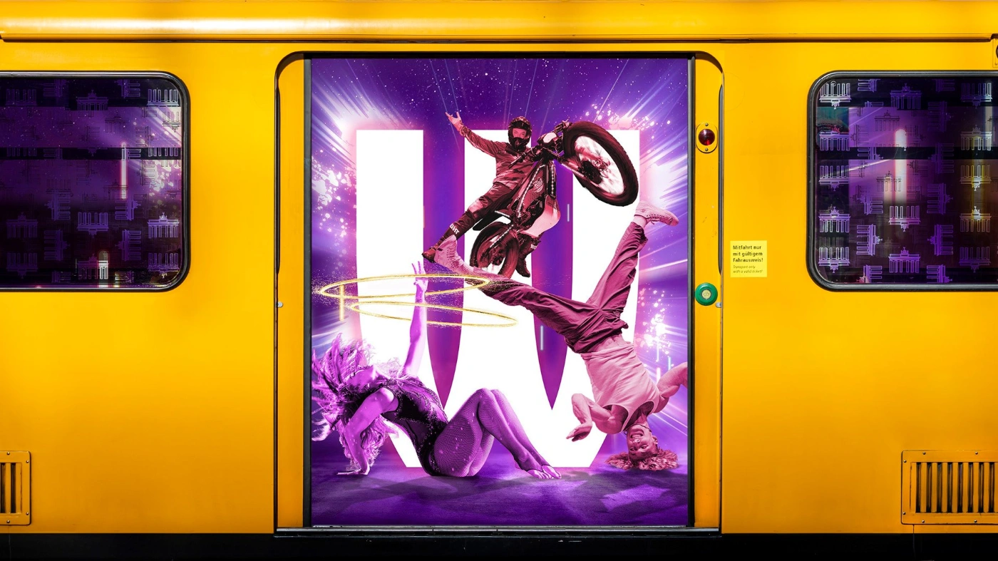 Fotocollage einer sich öffnenden U-Bahn, darin sind in lila Licht getaucht eine Tänzerin, ein Akrobat und ein Stuntman auf einem Motorrad zu sehen.