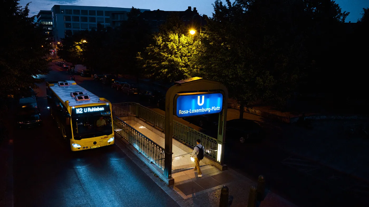 Ein Nachtbus der BVG fährt im Dunklen am Rosa-Luxemburg-Platz vorbei. 