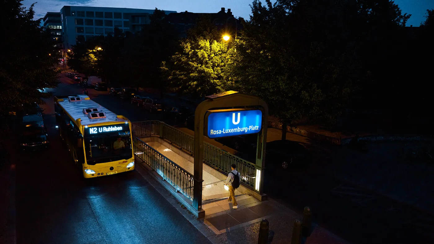 Ein Nachtbus der BVG fährt im Dunklen am Rosa-Luxemburg-Platz vorbei.
