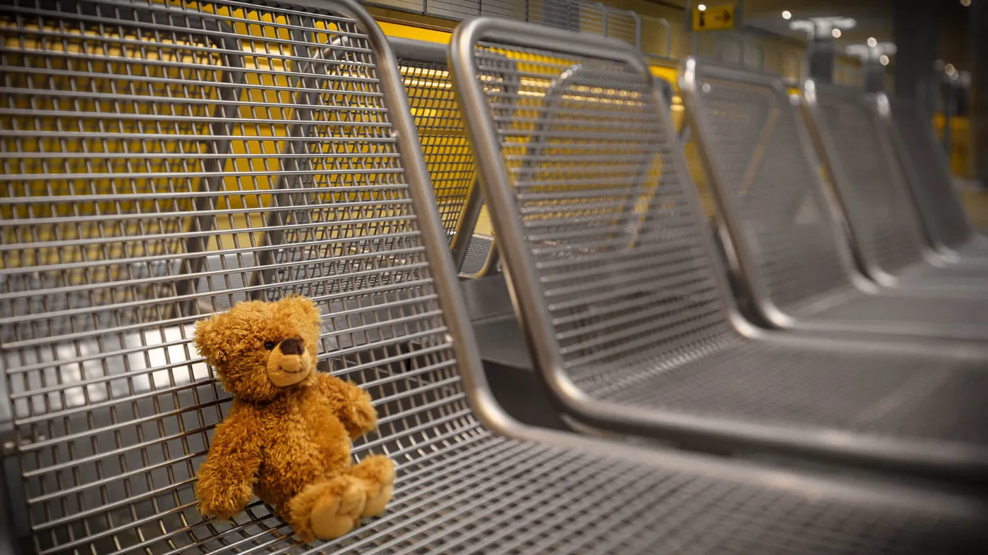 Ein verlorener, kleiner Teddy sitzt auf einer Bank in einem U-Bahnhof und wartet darauf, zum Fundbüro gebracht zu werden.