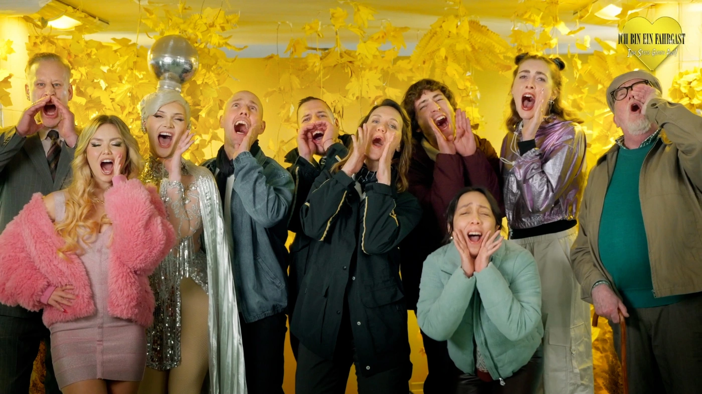 Die Teilnehmer von "Ich bin ein Fahrgast, ich steig hier aus" sind auf einem Gruppenfoto zu sehen. Sie stehen beieinander, halten die Hände an den Mund und öffnen den Mund zum Schrei.