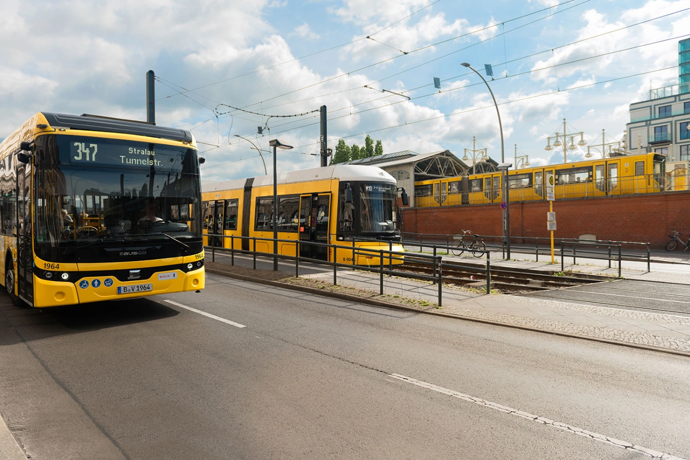 Die Fahrzeige der BVG auf gelbem Hintergrund: Eine U-Bahn, eine Tram und ein Bus. 