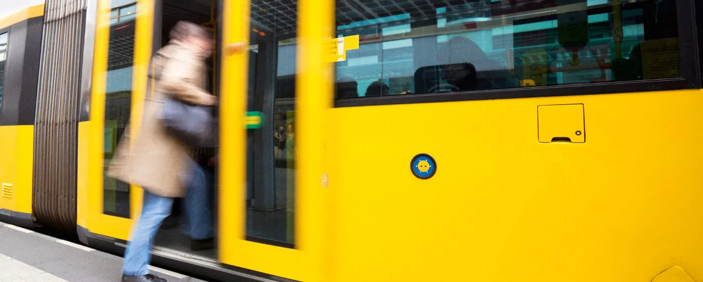 Eine Frau steigt in eine Tram der BVG ein.