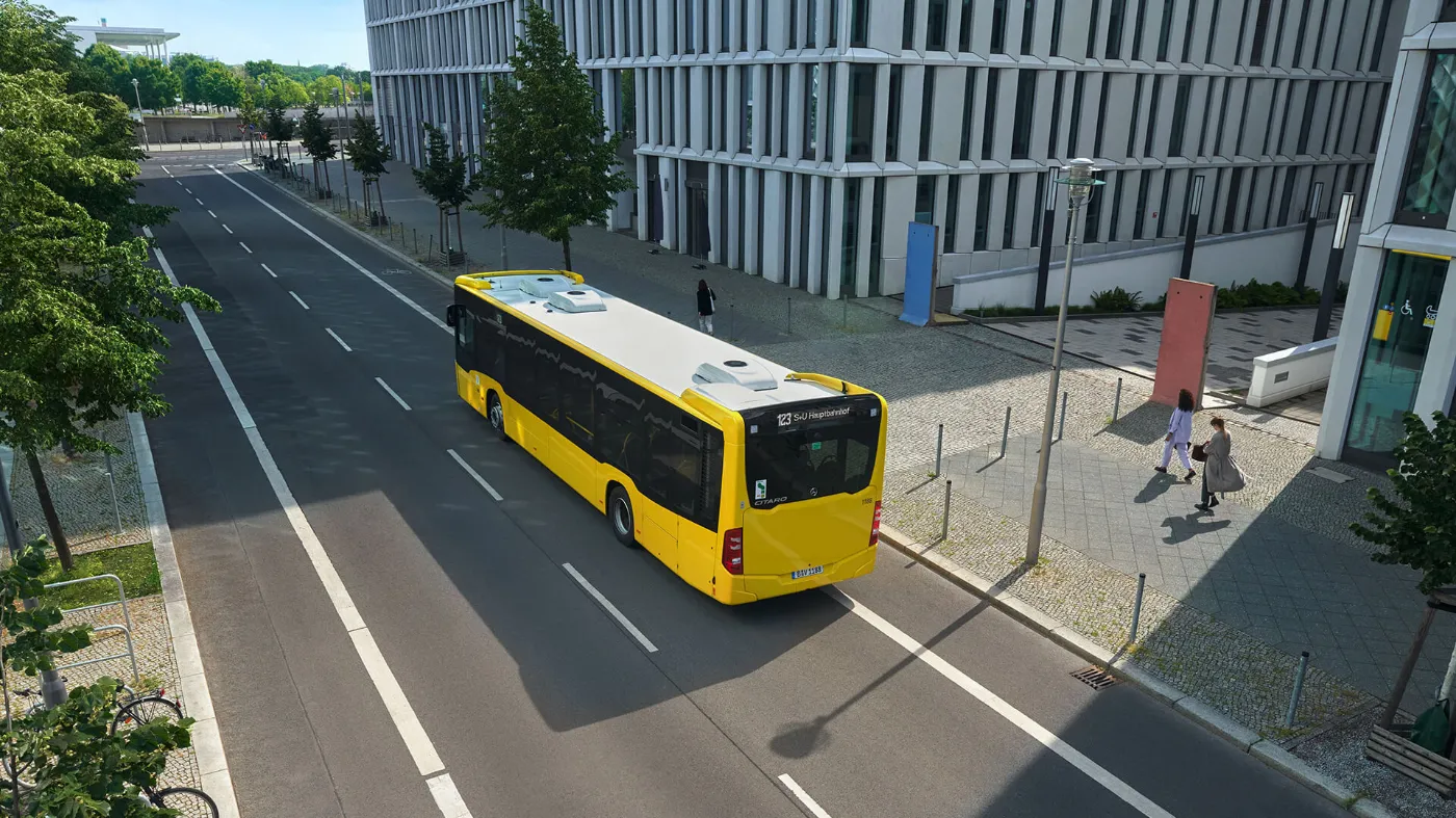 Ein Bus der BVG fährt zwischen Häusern entlang.