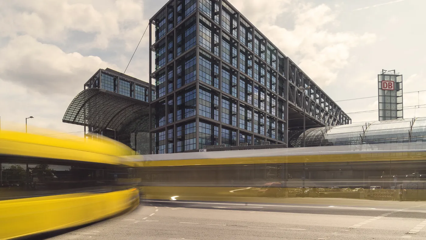 Blick auf den Hauptbahnhof, im Vordergrund sind verschwommen Fahrzeuge der BVG zu sehen.