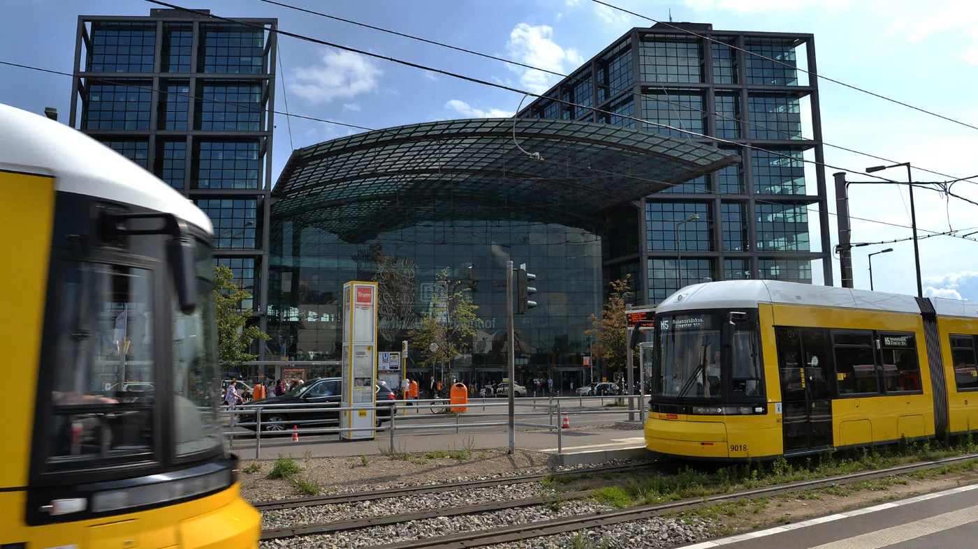 Blick auf den Haupteingang des Hauptbahnhofs. Davor sind 2 Trams zu sehen.