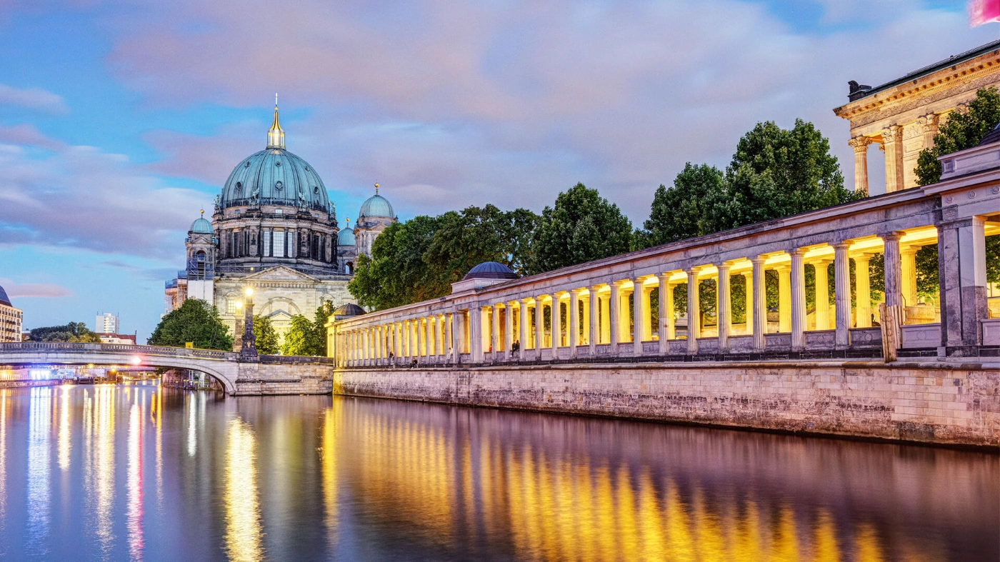 Zu sehen ist der Blick auf den Berliner Dom und die Friedrichsbrücke bei Sonnenuntergang.