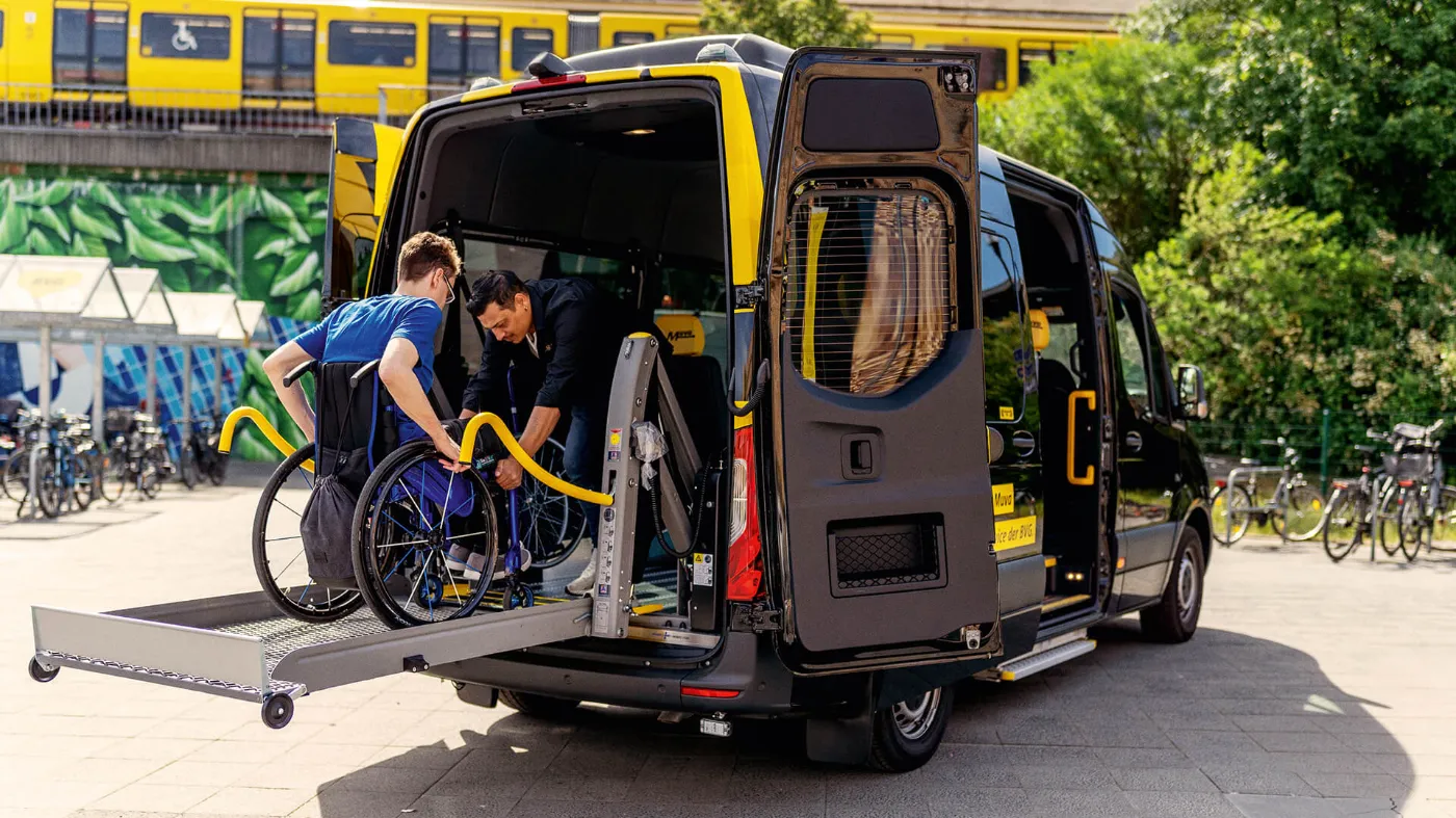 Ein Fahrer des BVG Muva hilft einer Person im Rollstuhl in das Fahrzeug. 