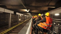 Menschen mit Schutzhelm und Schutzweste sitzen während der Fahrt auf dem U-Bahn-Cabrio.