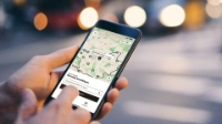 Eine Hand hält ein Smartphone, auf dem Bildschirm ist die Oberfläche der BVG Muva-App zu sehen. 