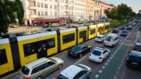 Eine Tram der BVG am Frankfurter Tor. Daneben stauen sich die Autos.