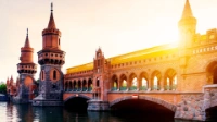 Die Oberbaumbrücke in Berlin, dahinter ein Sonnenuntergang.