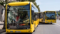 Ein parkender BVG-Bus wird von einem anderen überholt.