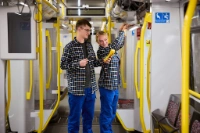 Zwei Elektroniker für Betriebstechnik prüfen etwas in der U-Bahn