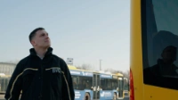 BVG-Auszubildener schaut sich den Bus von außen an.