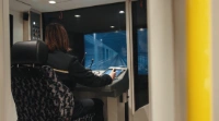 BVG-Auszubildene sitzt im U-Bahnsimulator.