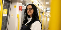 Eine Frau in BVG-Kleidung steht in einer U-Bahn