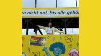 Frau steht im gelben CSD-Truck